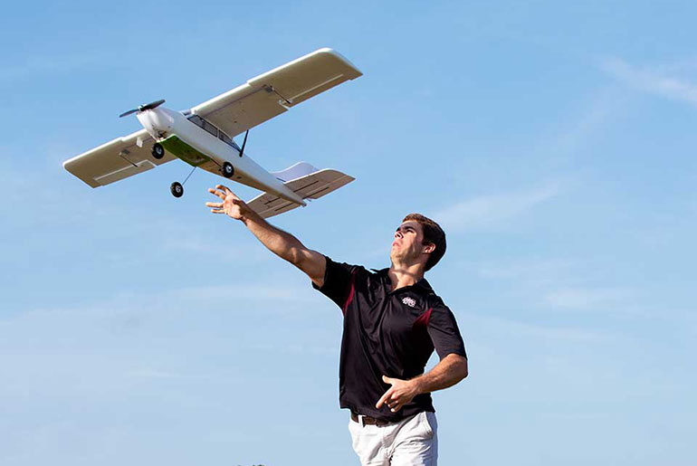 student launching a fixed-wing aircraft