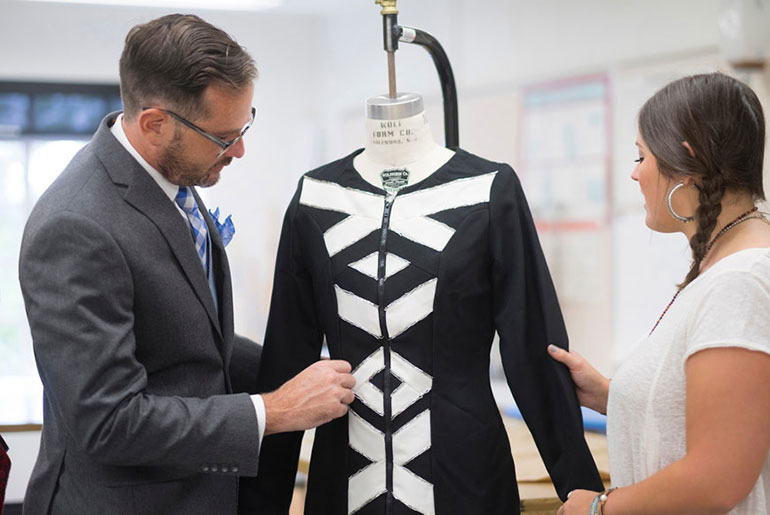 faculty member discusses fashion with female student