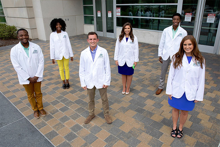 Six MSU students in white coats