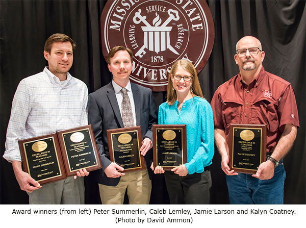 four faculty members pose with teaching awards