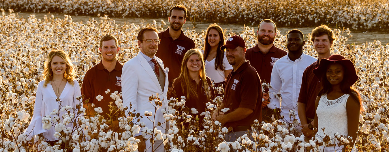students and faculty in cotton field