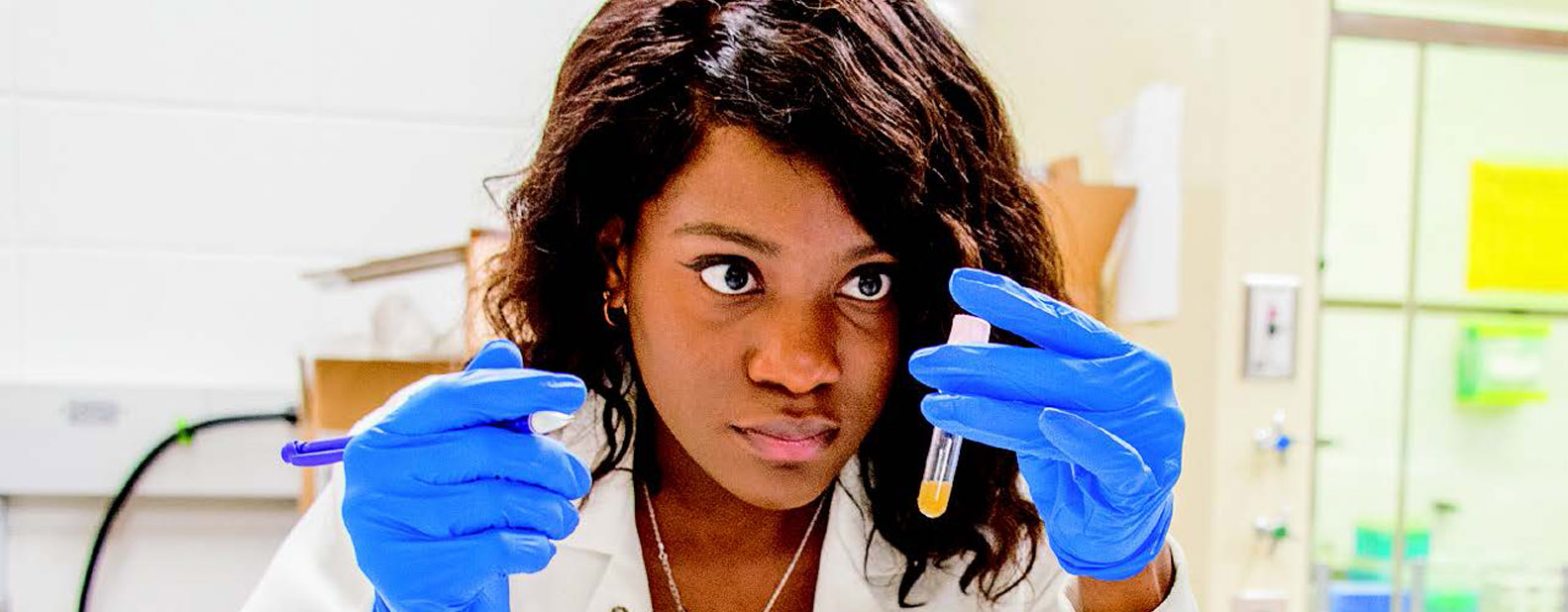 Student in a lab with a test tube in her hand