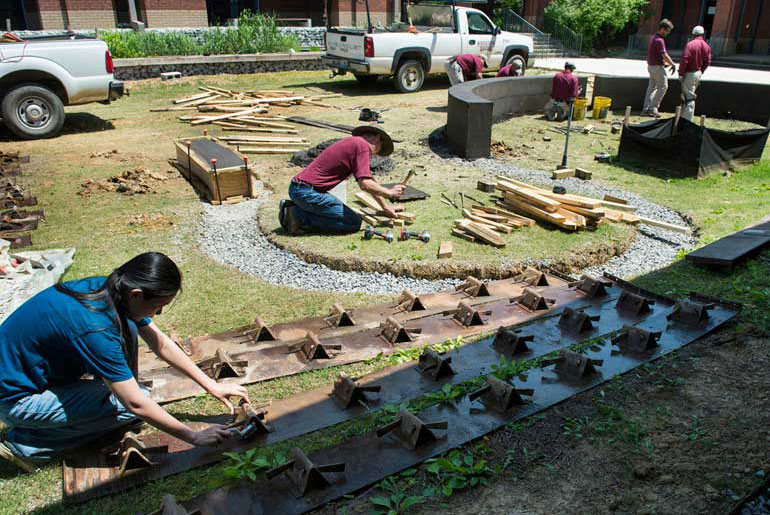 faculty and students work in landscape