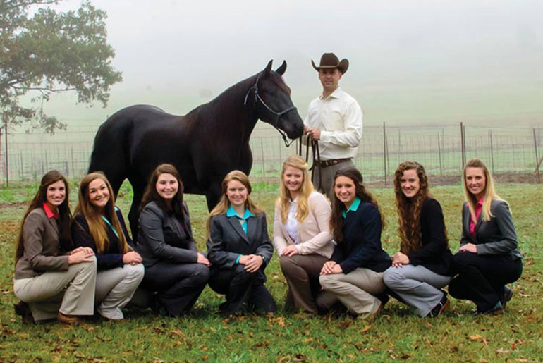 students and faculty with horse