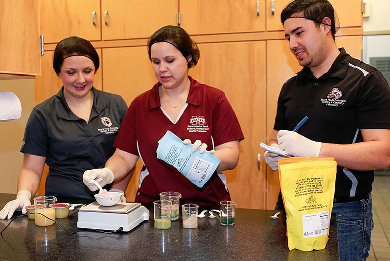 Three students work in test kitchen