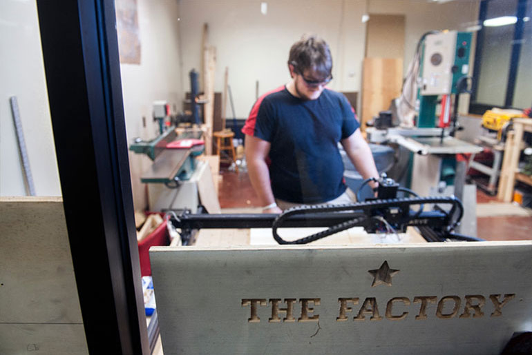 male student working with 3D printer