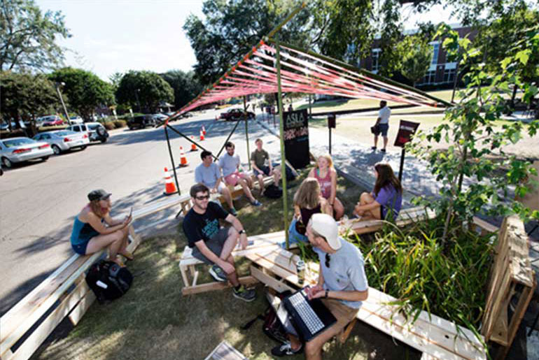 Students lounging in parking space turned into green area