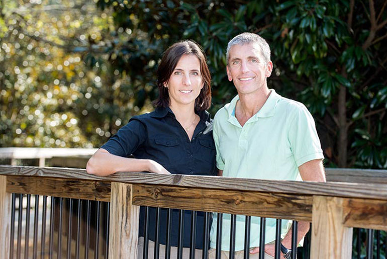 female and male student pose on bridge