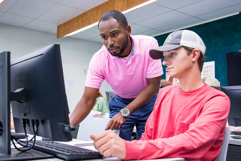 faculty and student working at computer