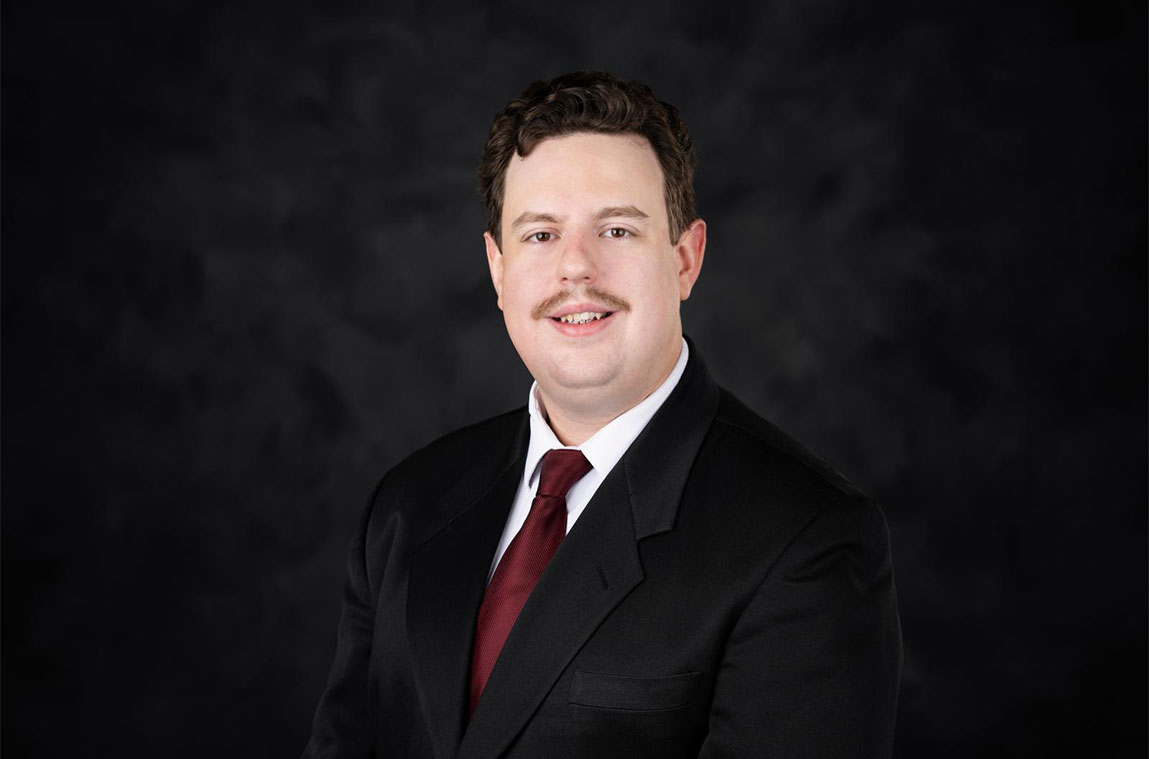 Man in black suit against a black background