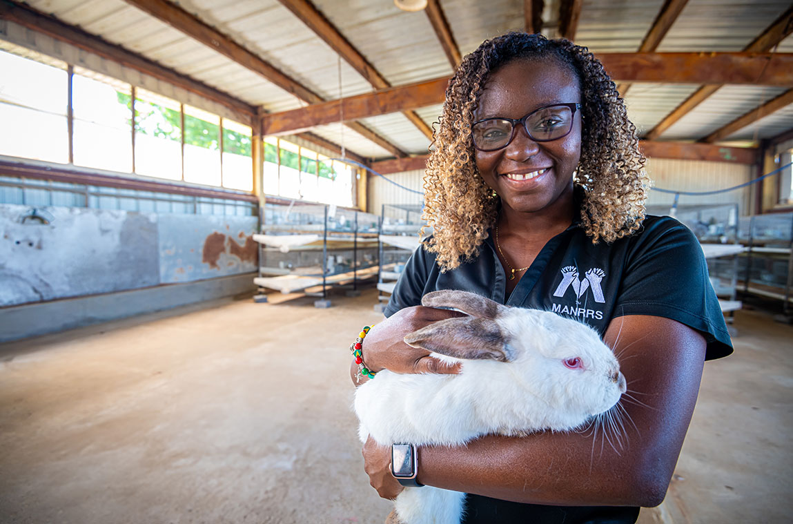Young woman holding a white rabbit