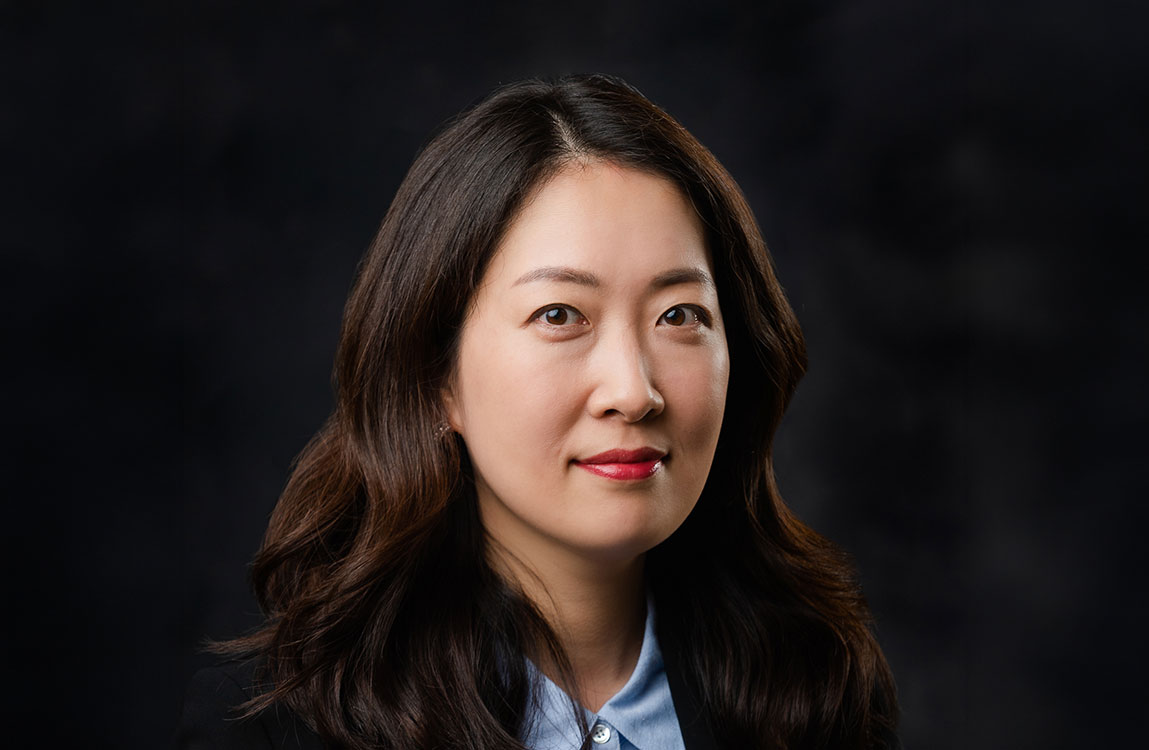studio portrait of a woman in a blue blazer with a black background