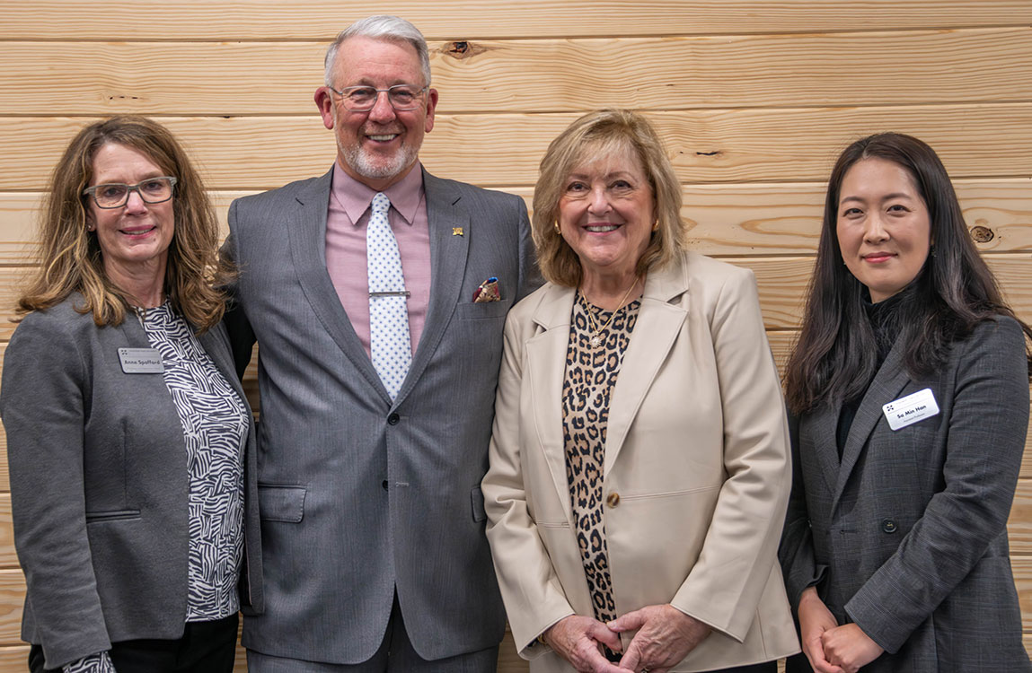Photo of four people celebrating a new endowed professor on the far right
