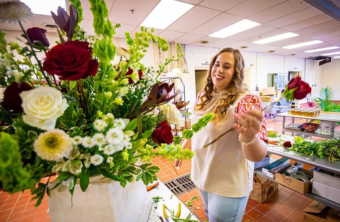 Woman with flowers making a flower arrangement. 