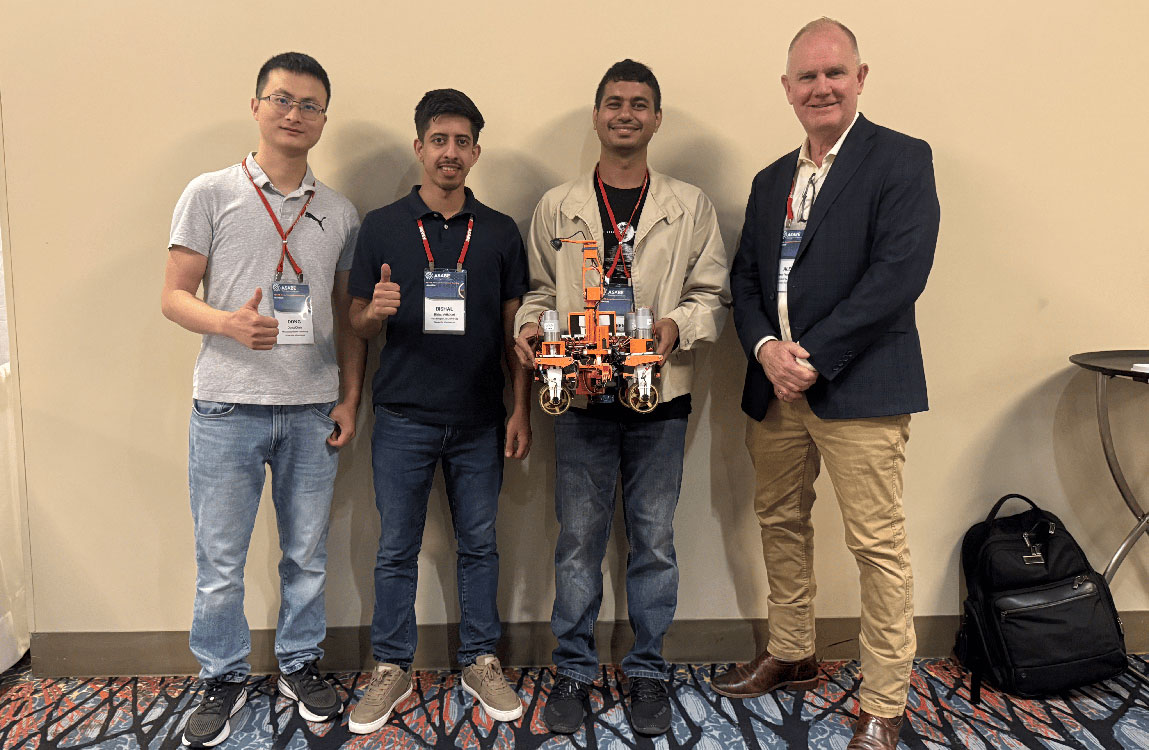 Students pose with robot
