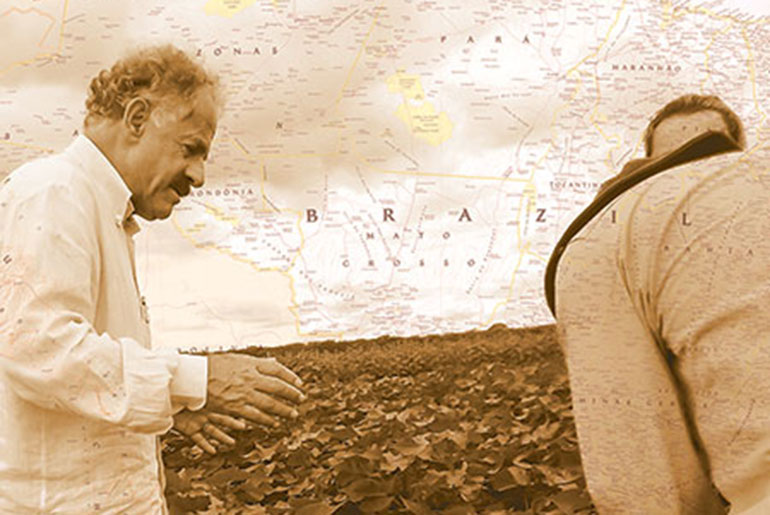 two men in a field with map in background