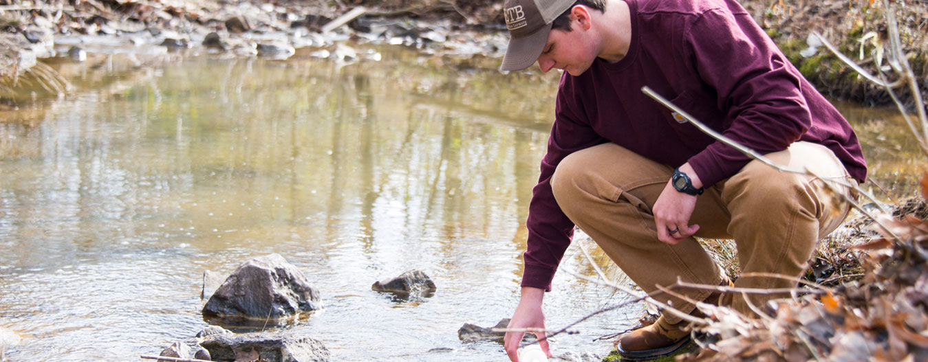 Male student measuring water quality