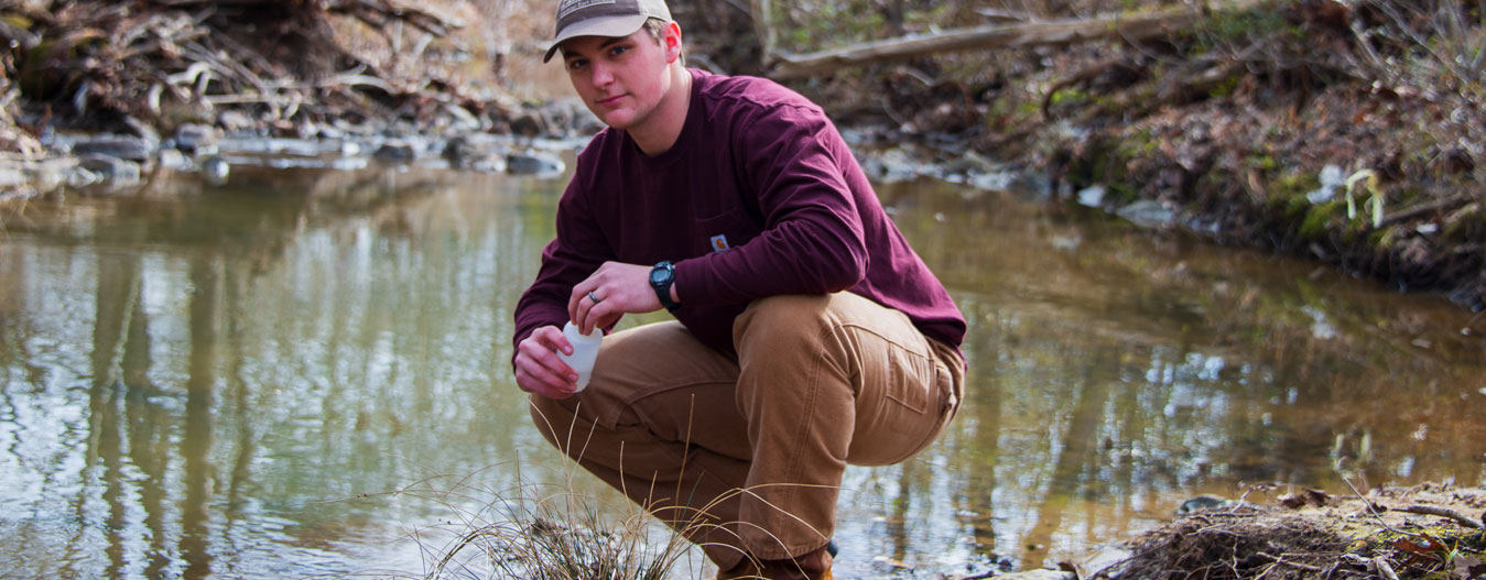 male student measuring water quality