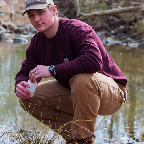 Male student measuring water quality